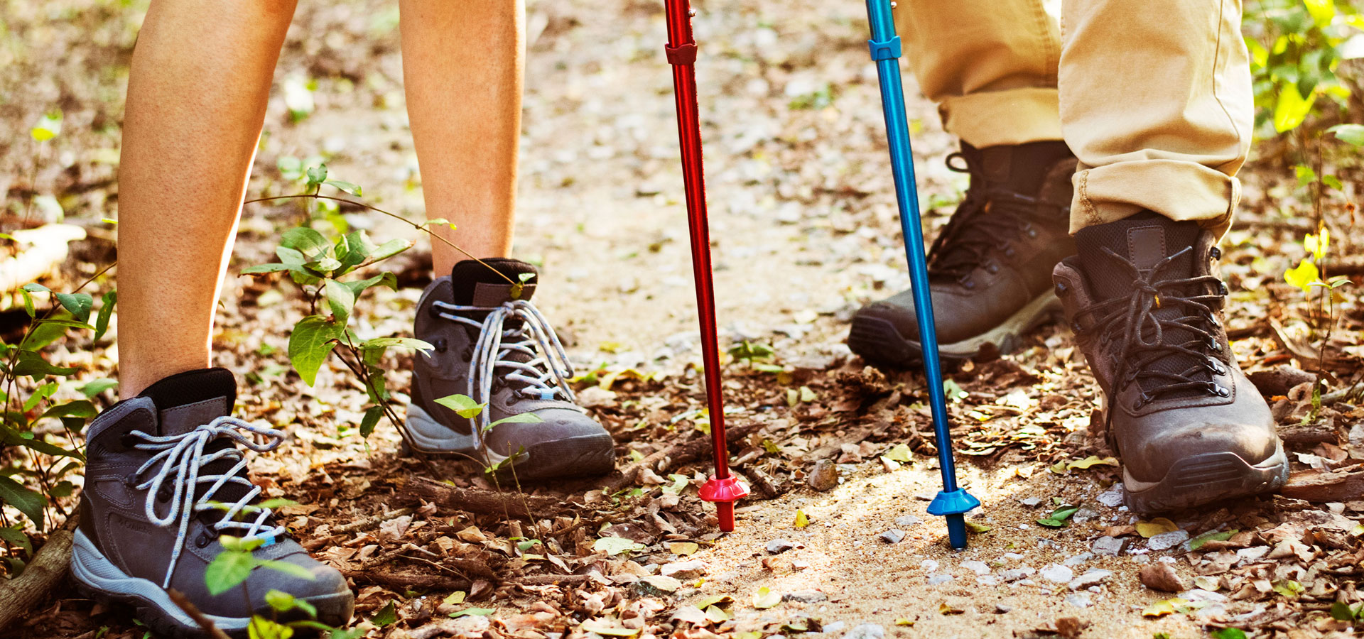 Ein paar Wanderschuhe und Nordic Walking Stöcke in Detailansicht